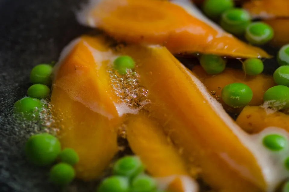 Carottes et petits pois en train de cuire