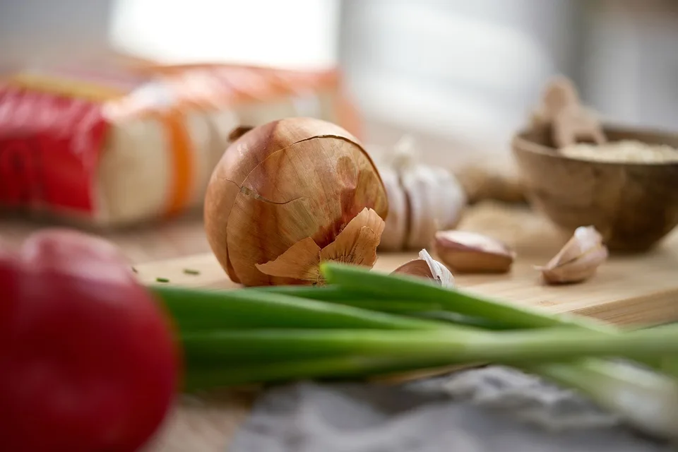 Oignons, ail et ciboule sur une table de cuisine